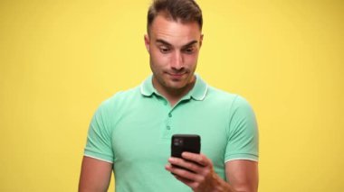 Çekici, sıradan bir adam cep telefonuyla mesaj atıyor, mutlu bir şekilde şaşırıyor sonra heyecanlanıyor, sarı arka plandaki başarıları kutluyor.