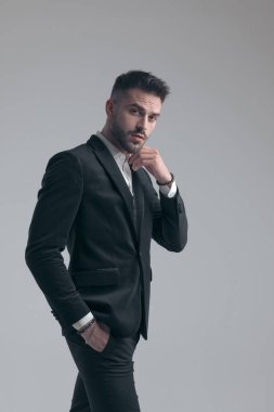 Yakışıklı, zarif bir adam. Yakasını cebinde taşıyordu. Gri stüdyo arka planında yürürken takım elbise giyiyordu.