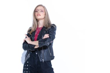 Çekici manken el ele tutuşuyor ve işaret ediyor. Duruyor, gözlük ve deri ceket giyiyor ve beyaz stüdyo arka planında duruyor.