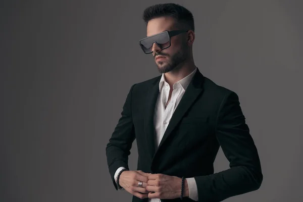 Confident Fashion Model Fixing His Jacket Looking Away Wearing Suit — Stock Photo, Image