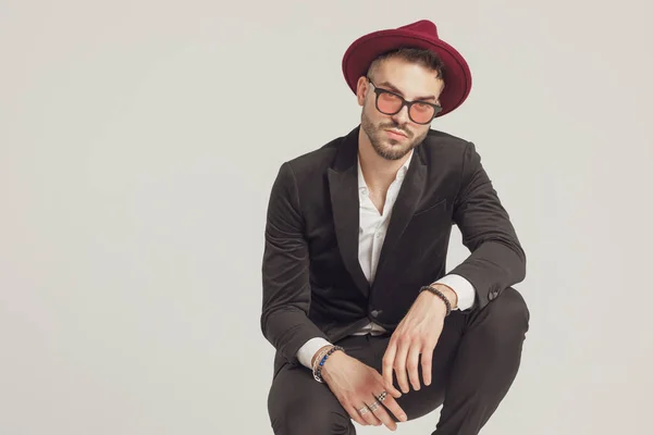 Modello Moda Serio Indossare Occhiali Sole Cappello Mentre Accovacciato Sfondo — Foto Stock