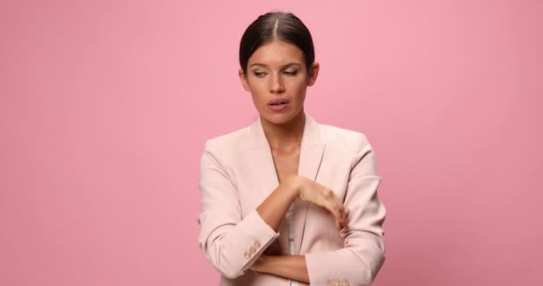 若い美人実業家が顎を引っ掻いて何かを考えピンクを背景に混乱しています — ストック動画