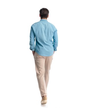 Mavi kot gömlekli sıradan bir gencin arka planda el ele tutuşması ve beyaz arka planda yürümesi.