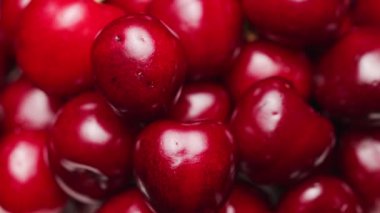 Taze kırmızı kirazların parlak ciltli ve sağlıklı beslenme konseptini gösteren canlı renkli videolarını kapat.