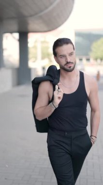 Gözlüklü havalı bir genç adam omuz omuza yürüyor ve Romanya şehrine bakıyor, Sibiu.