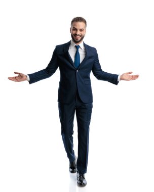 Lacivert takım elbiseli, beyaz arka planda gülümseyen olgun bir iş adamının tam vücut resmi.