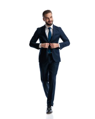 Beyaz arkaplan önünde lacivert takım elbise giyen kendine güvenen zarif bir adam.