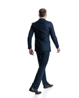 Beyaz arka planda yürüyen lacivert takım elbiseli zarif iş adamının arka planı.