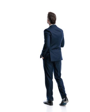 Lacivert takım elbiseli zarif bir adamın arka planda el ele yürüdüğünü ve beyaz arka planda başka yöne baktığını gördüm.