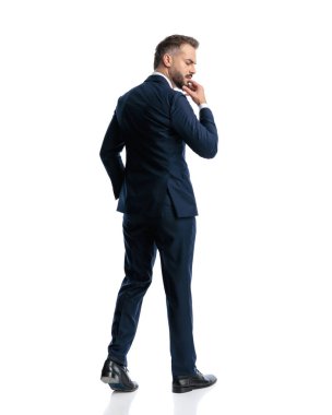 Düşünceli genç işadamı, düşünceli, düşünceli, çenesine dokunan ve beyaz arka planda yürüyen