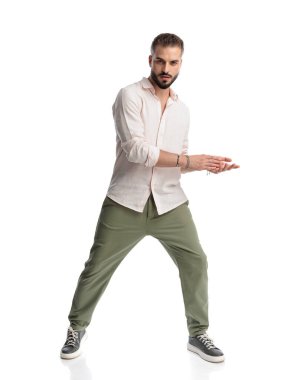 Beyaz arka planda poz verirken el ele tutuşan seksi sakallı adam.