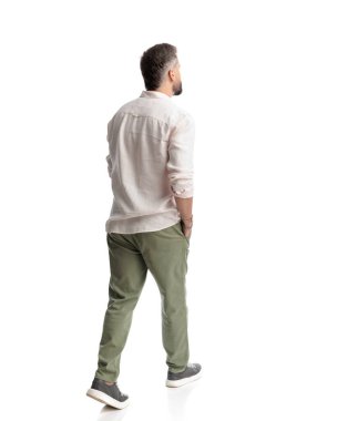 Beyaz arka planda elleri ceplerinde yürüyen sıradan bir gencin arka planı.