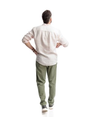 Önüne bakıp beyaz arka planda yürüyen sıradan bir genç adamın arka plan görüntüsü.