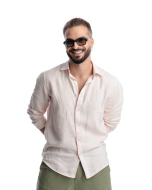 Güneş gözlüklü çekici bir gencin portresi. Arkadan el ele tutuşup beyaz arka planda gülümsüyor.