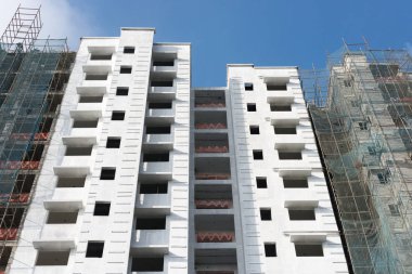 Bir altında inşaat çok katlı apartman binası. Kısmen beyaz boyalı. Yukarı doğru görünümü görüntü