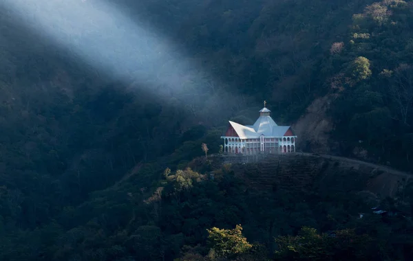 En stråle lyser upp en välsignad kyrka i bergen — Stockfoto