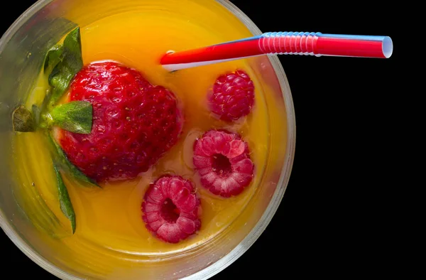 Alkolsüz kokteyl ile çilek ve ahududu suyu ve saman siyah arka plan ile yüksek görünümü.