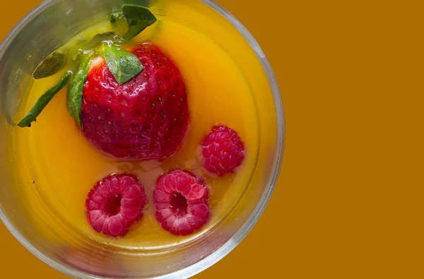 Alkolsüz kokteyl turuncu arka plan ile çilek ve ahududu suyu ile yüksek görünümü