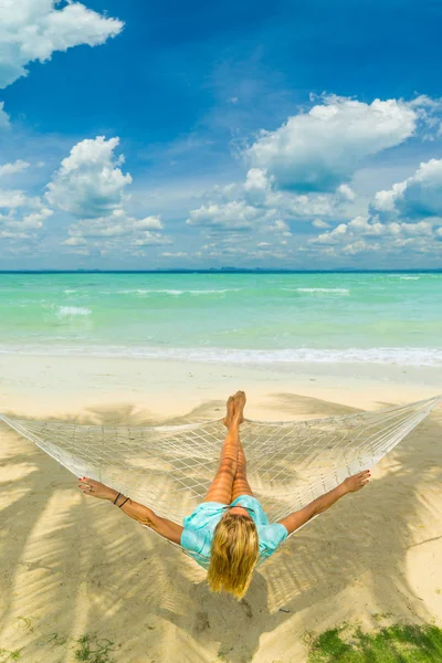 帽子をかぶった女性が浜のハンモックに座っている 旅行と休暇のコンセプト — ストック写真