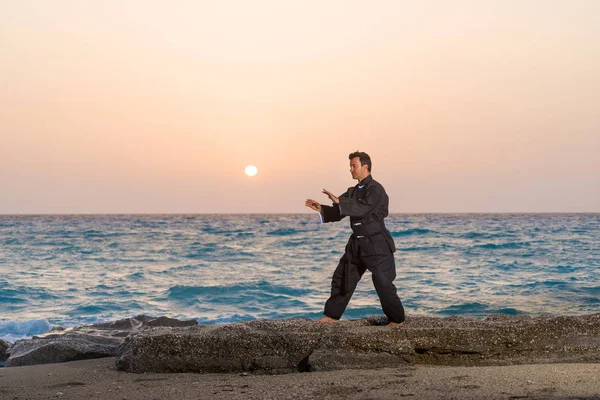 Człowiek Wykonuje Tai Chi Ruchów Przeciw Zachód Słońca Plaży — Zdjęcie stockowe