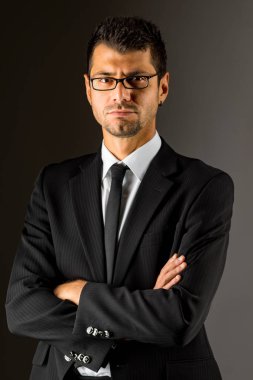 Siyah elbiseli ciddi bir adam. koyu arka plan.