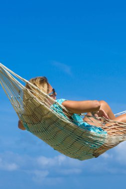 Hamak sahilde oturan kadın. Seyahat ve tatil kavramı.