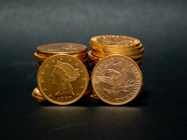Koyu arka plan üzerinde istifleme gerçek altın para sikke yakın çekim