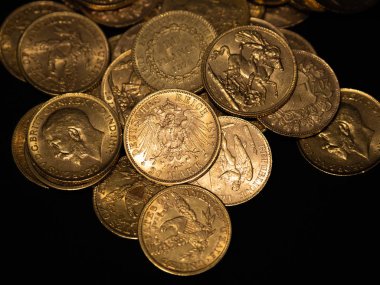 Koyu arka plan üzerinde istifleme gerçek altın para sikke yakın çekim