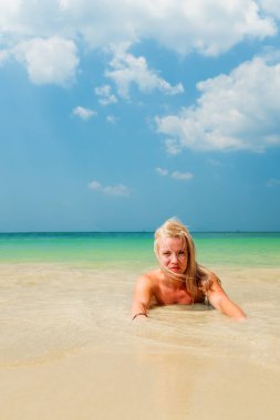 Tropik plajda dinlenen bir kadın.