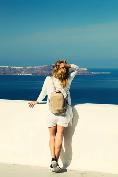 Luxury travel vacation woman looking at view on Santorini island in Greece. Amazing view of sea and Caldera.