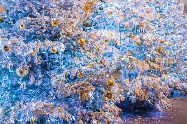 金色的气泡和许多的灯光挂在圣诞树装饰 关闭的背景 新的一年冷杉树分支在雪摄影 关闭装饰白色圣诞树庆祝 — 图库照片