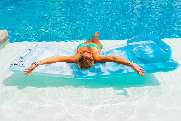 高級熱帯リゾートのスイミング プールでリラックスした Lilo を持つ女性 — ストック写真