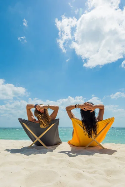 Dos mujeres disfrutando de sus vacaciones en la playa tropical — Foto de Stock