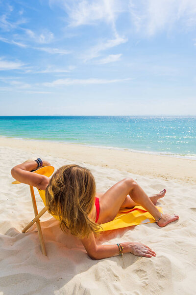 Женщина наслаждается отдыхом на трансате на тропическом пляже
 