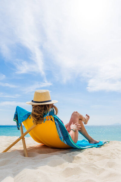 Женщина наслаждается отдыхом на трансате на тропическом пляже
 