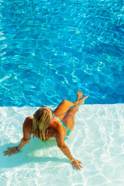 Mulher relaxante na piscina no resort de luxo — Fotografia de Stock