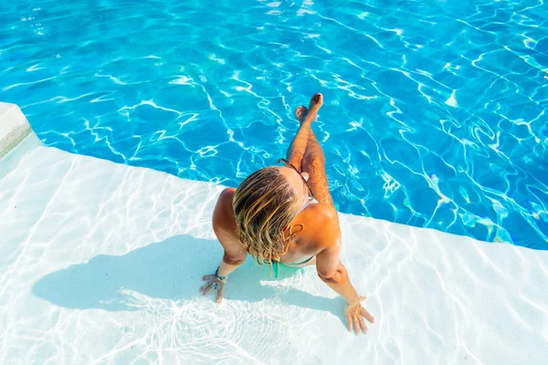 Vrouw ontspannen bij het zwembad in het luxeresort — Stockfoto