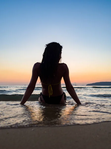 Silueta de una mujer en la playa al atardecer —  Fotos de Stock