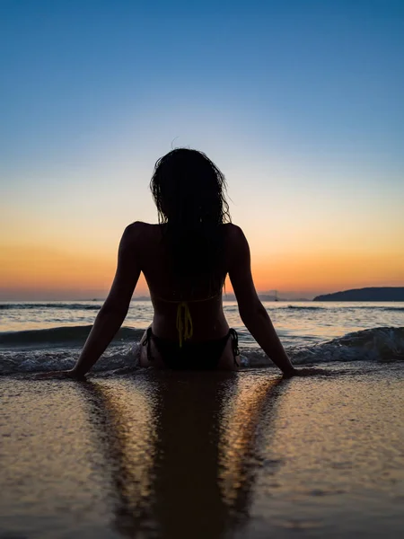 Silueta de una mujer en la playa al atardecer —  Fotos de Stock