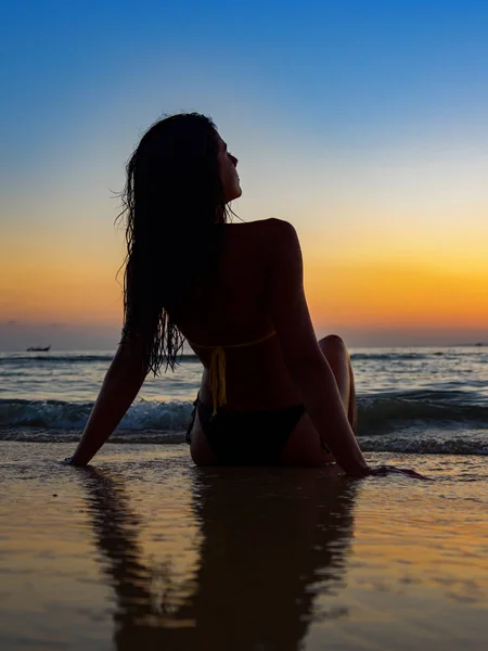 Silhouet van een vrouw op het strand bij zonsondergang — Stockfoto