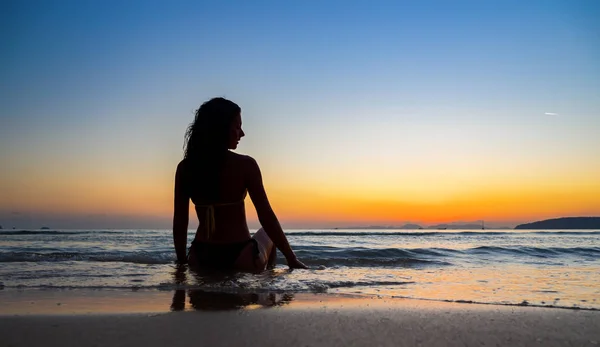 Silhouette di una donna sulla spiaggia al tramonto — Foto Stock