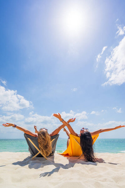 Две женщины наслаждаются отдыхом на тропическом пляже
 