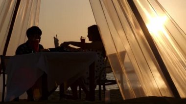 Gün batımında sahilde iki kişilik yemek masası