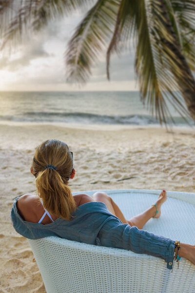 Женщина наслаждается отдыхом на трансате на тропическом пляже
 