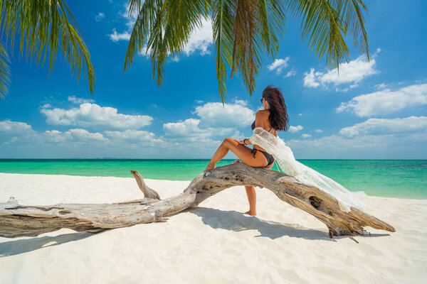 женщина загорает на тропическом пляже
