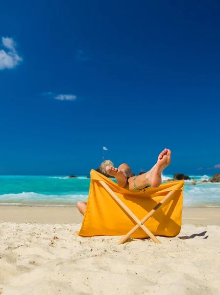 Donna godendo le sue vacanze su un transat sulla spiaggia tropicale — Foto Stock