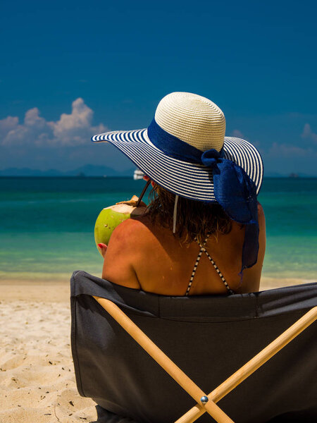 Женщина наслаждается отдыхом на трансате на тропическом пляже
 