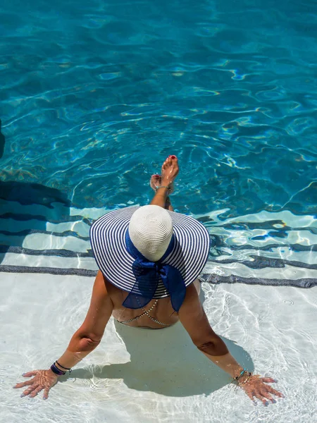 在温泉胜地的游泳池里放松的女人。r — 图库照片