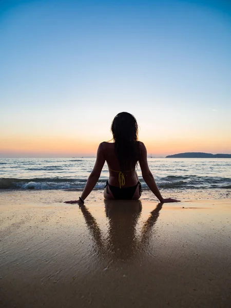 Silhouet van een vrouw op het strand bij zonsondergang — Stockfoto