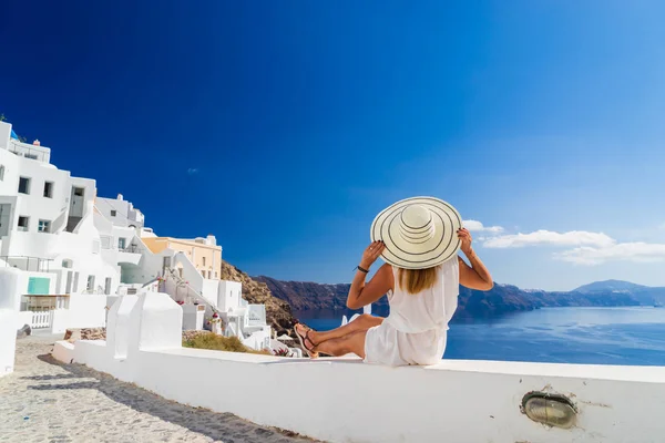 Luxe reizen vakantie vrouw kijkt aan uitzicht op Santorini eiland — Stockfoto